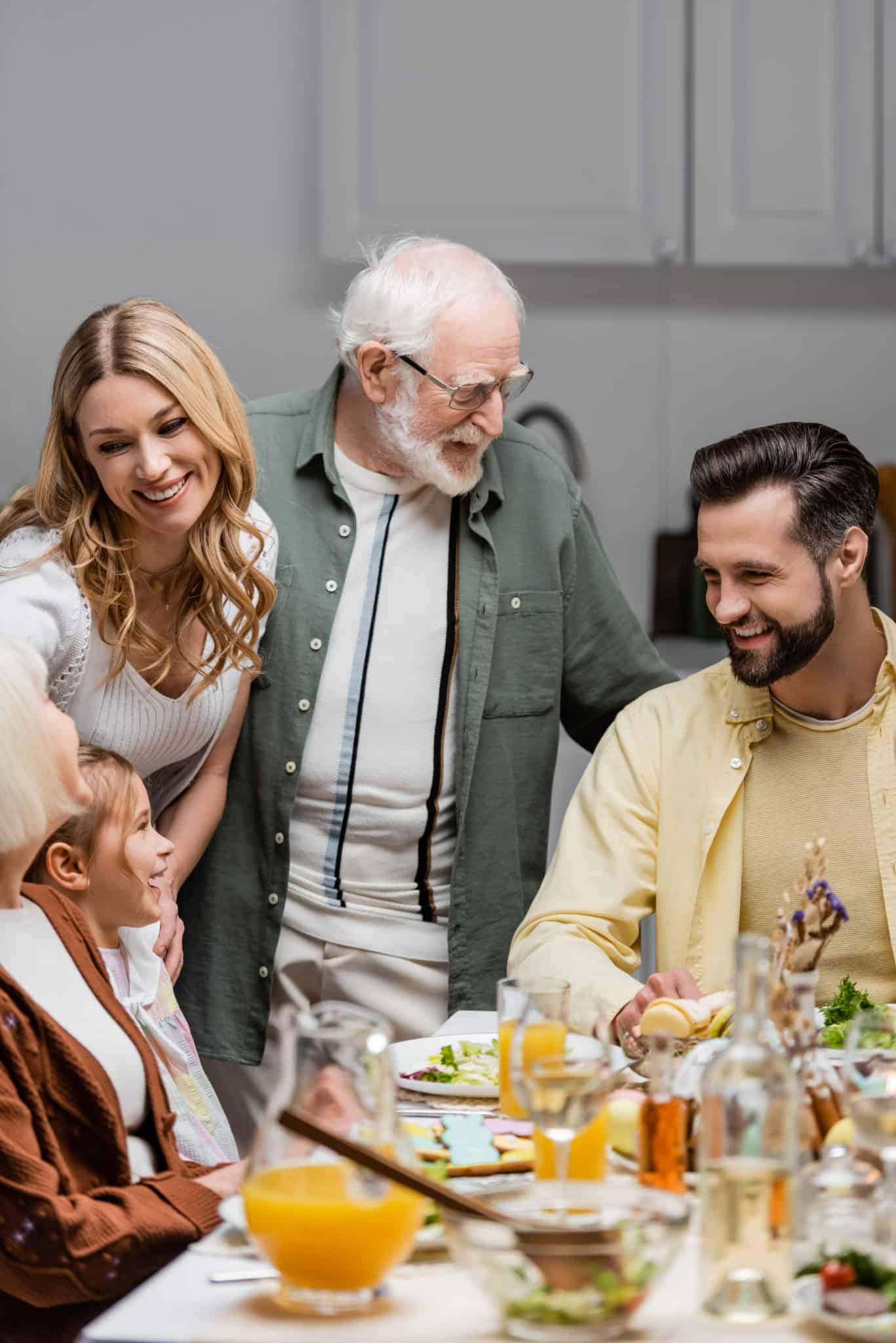 Happy Family Smiling Near Table Served With Eastern Dinner.