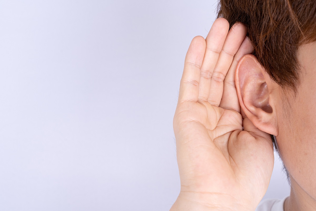 child cupping ear to hear better